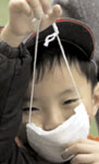A Chinese boy puts on a mask in Beijing, April 11. (REUTERS)