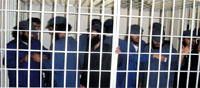 Al-Qaeda suspects shown in their cell during the hearings. The suspects threatened on Saturday to amputate the leg of the chief prosecutor Saeed al-Akil amid the shock of attendees. Photo by Mohamed Al-Qadhi / YT Staff.